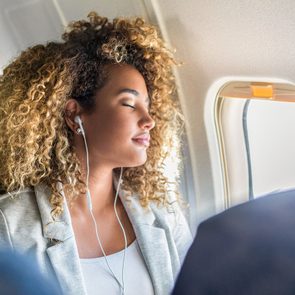 Young Woman Naps During Long Airplane Flight