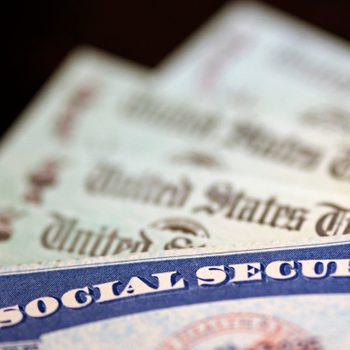 Social security card on top of several social security checks