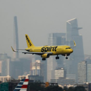 Yellow Spirit Airlines plane with skyscrapers in the background