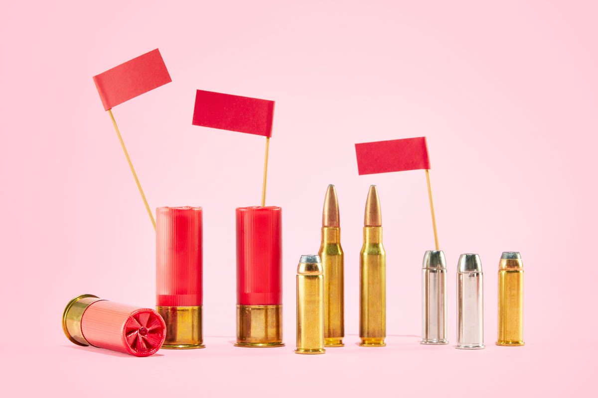 various ammunition with red flags against a pink background