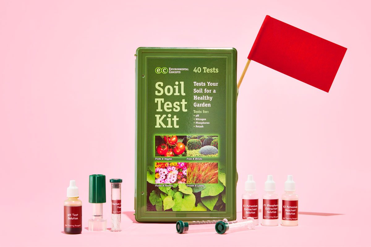 chemical soil test kit with red flags against a pink background