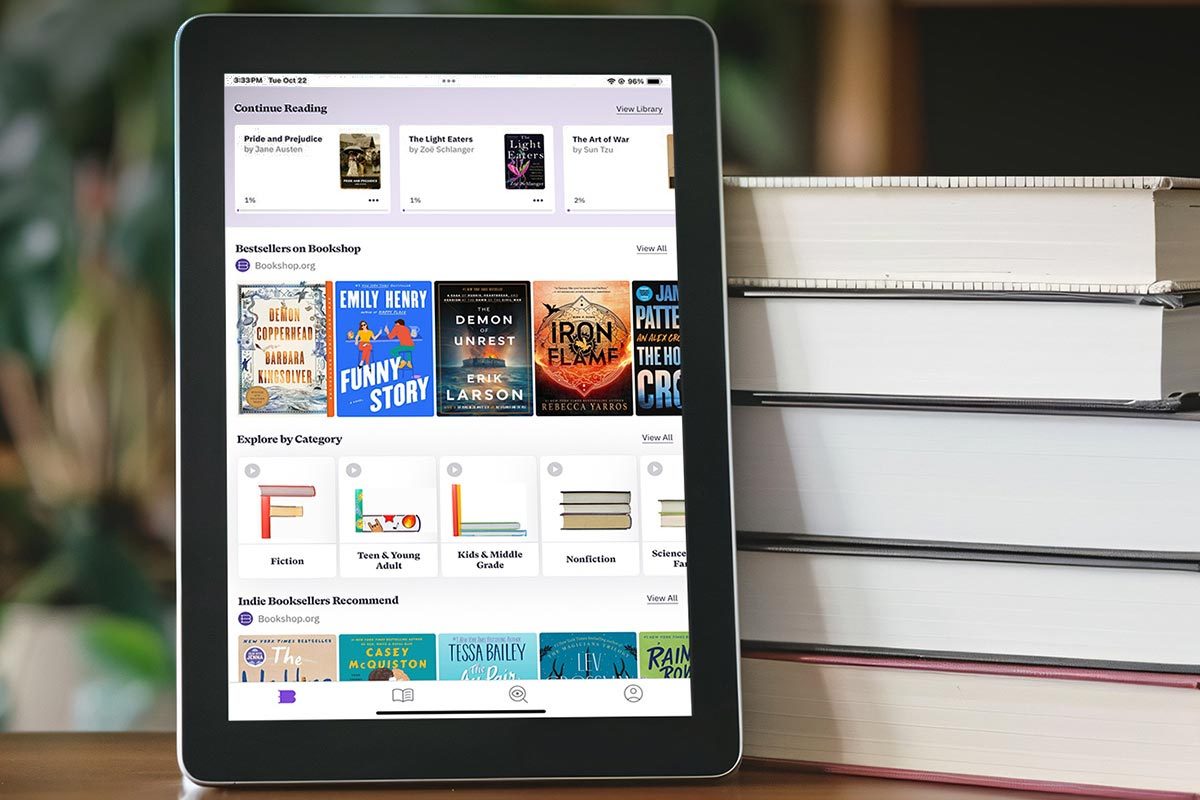 Tablet with an ebooks app on it, next to a stack of physical books