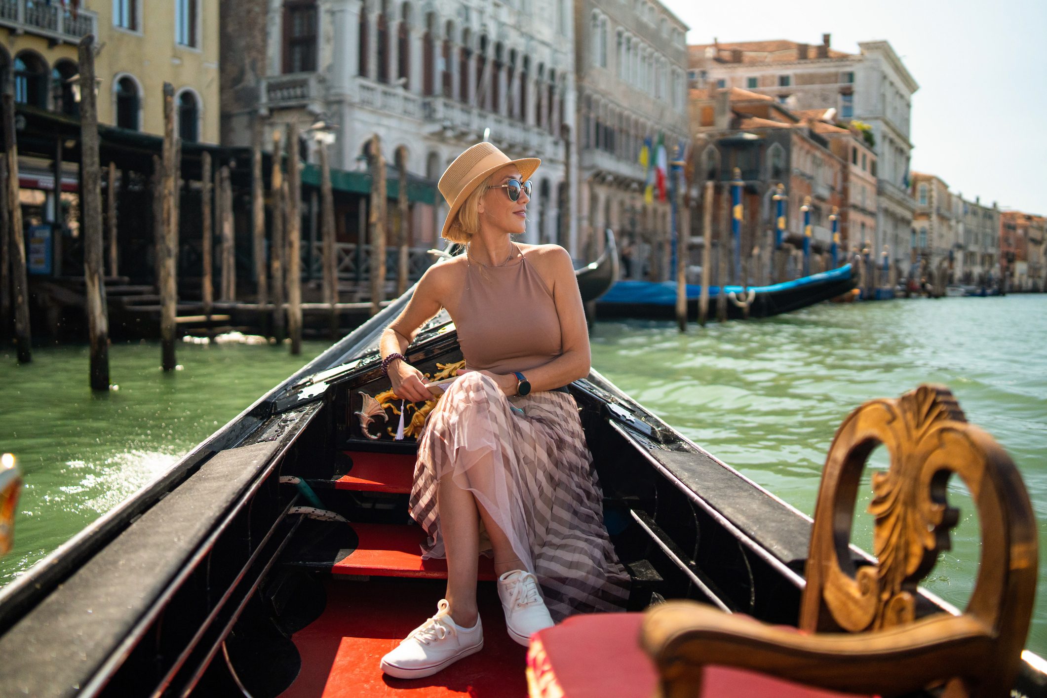 Woman on a gondola tour sailing in Grand Canal in Venice