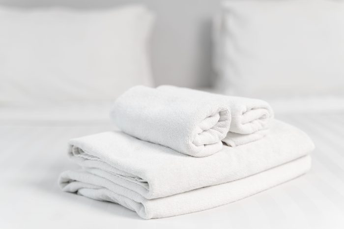 A cropped shot of an arranged towel on the bed in a hotel bedroom