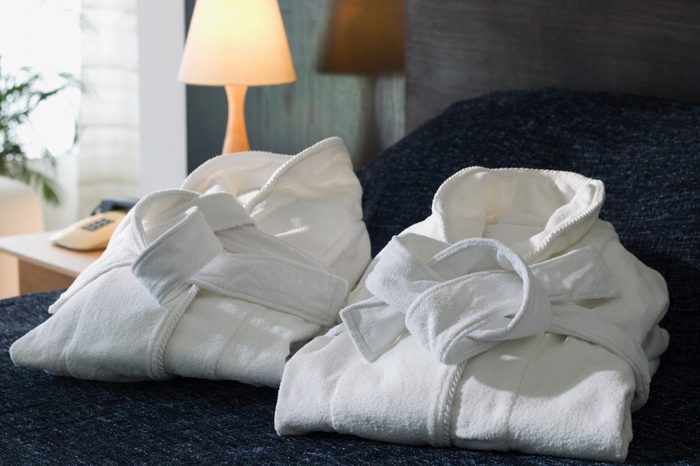 Folded bathrobes on a hotel bed