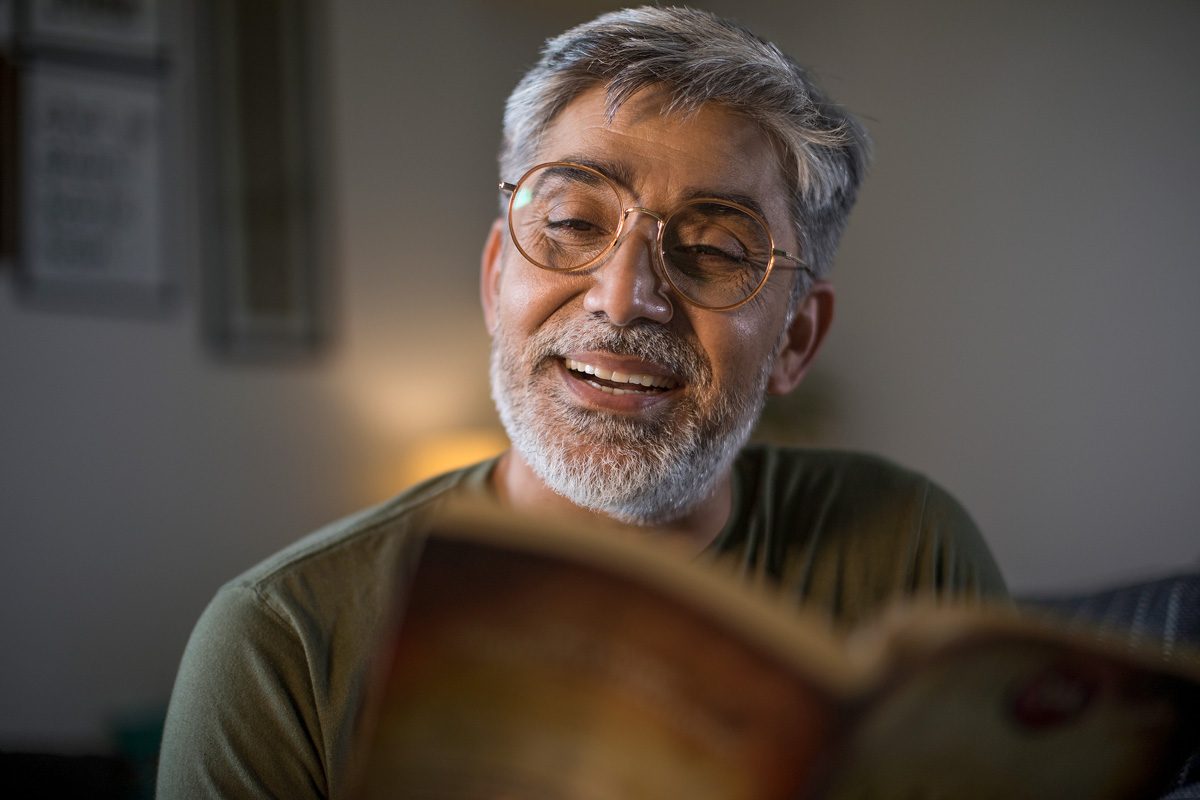 man reading book at home