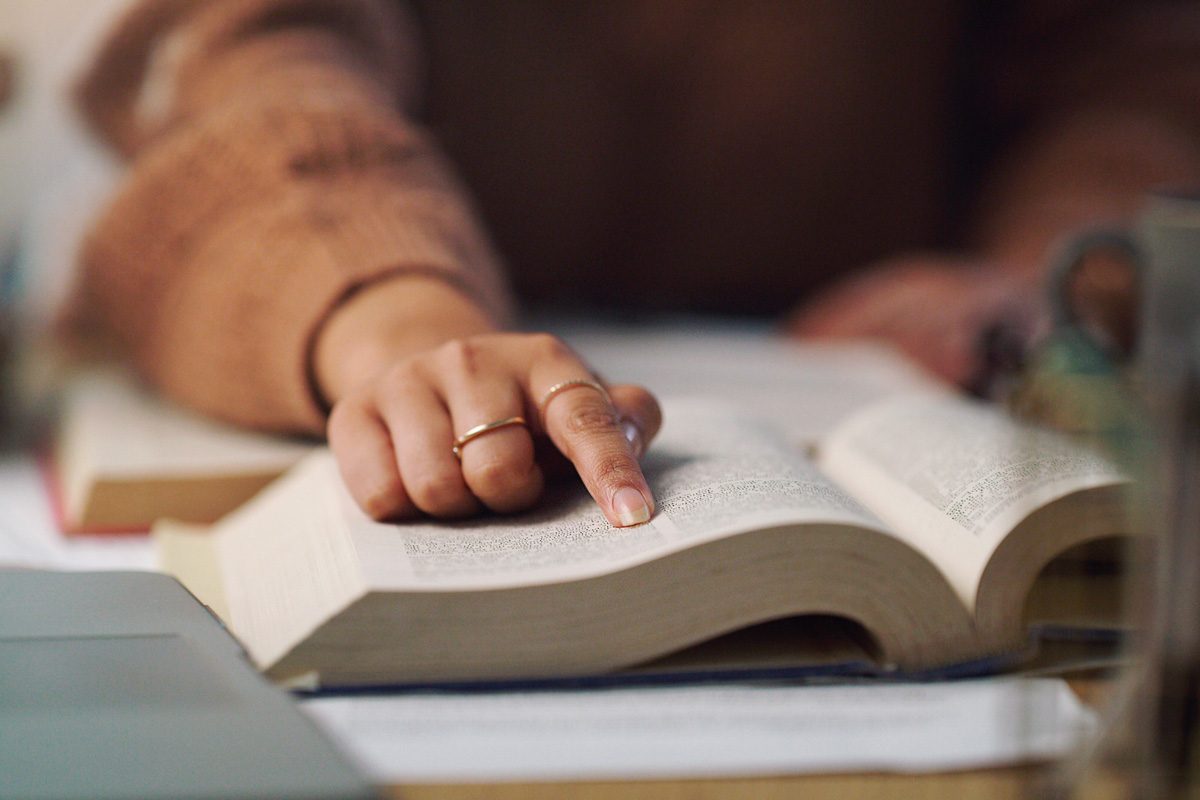 woman tracing sentences with finger while reading