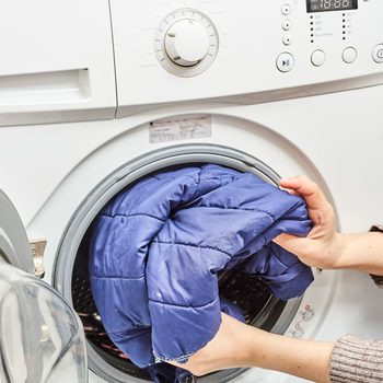 Woman Washing Winter Coat In The Washing Machine